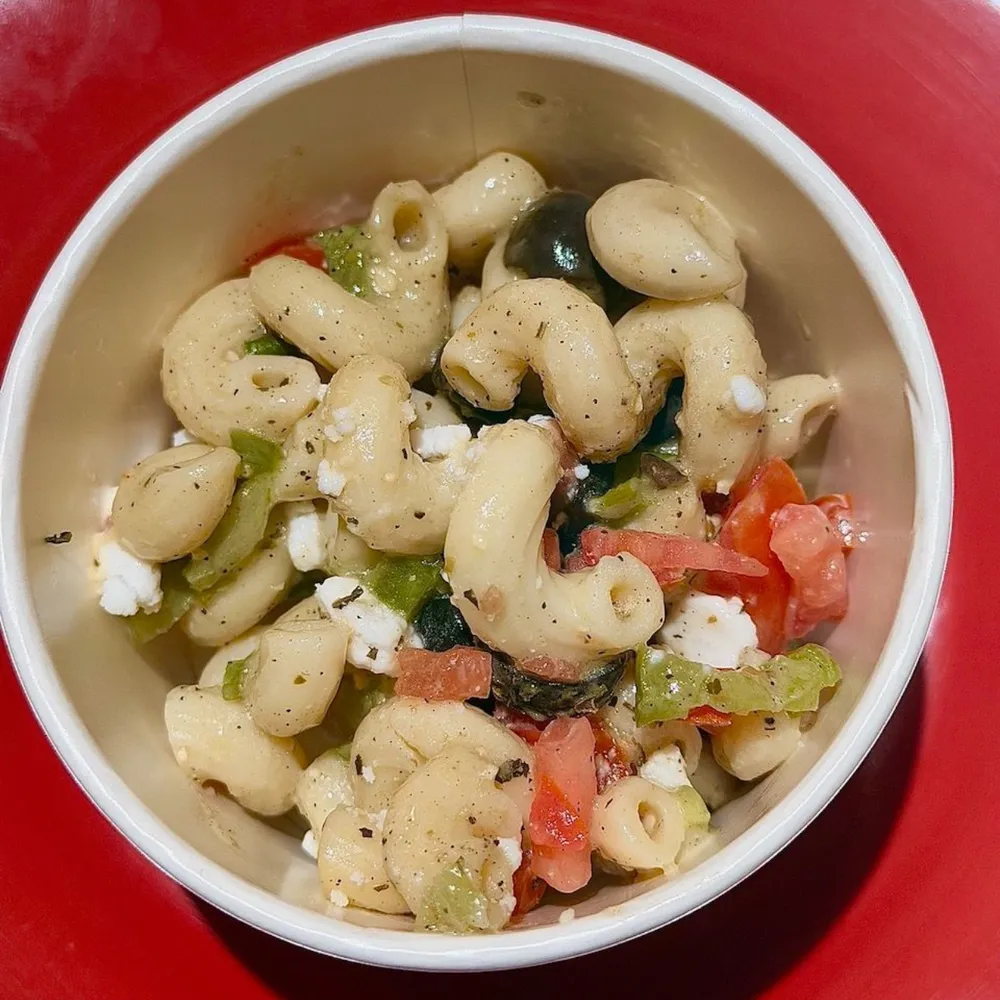 A bowl of The Jugular pasta salad with olives and bell pepper