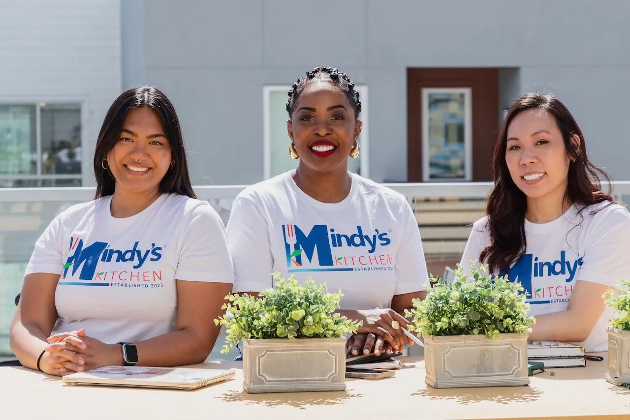 The Mindy&rsquo;s Kitchen team smiling in matching Mindy&rsquo;s Kitchen shirts