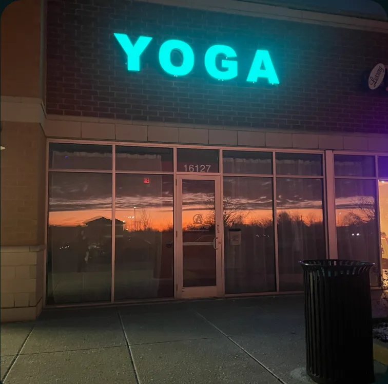 The Teal Yogi storefront at dusk, with the glowing YOGA sign above the door