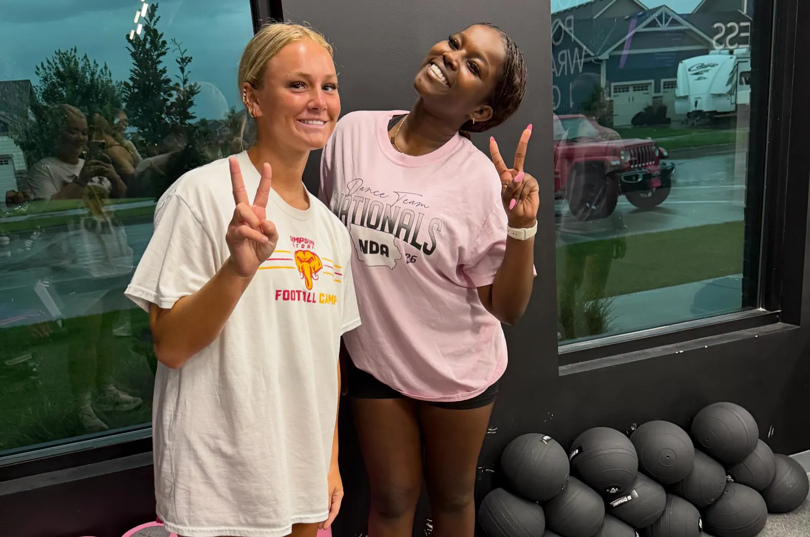 Two young athletes smiling and throwing peace signs after a session