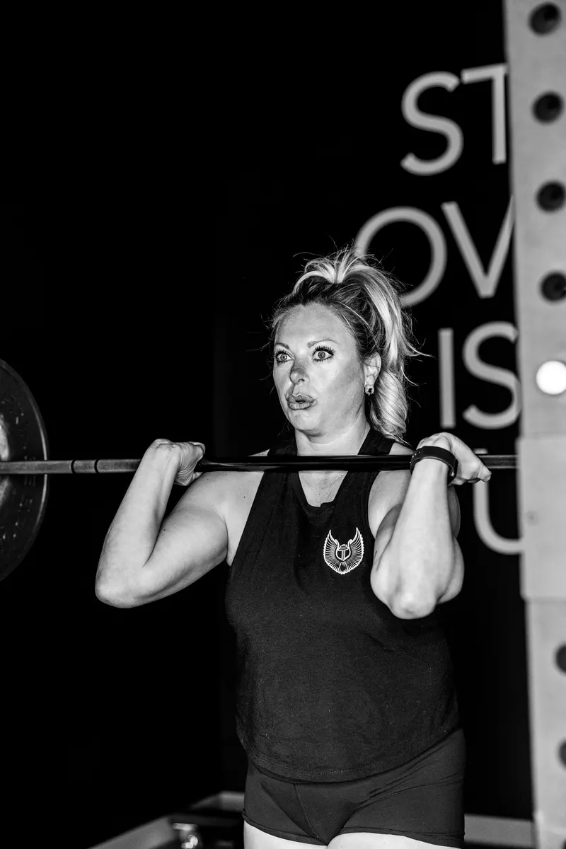 A member holding a barbell in the front rack position