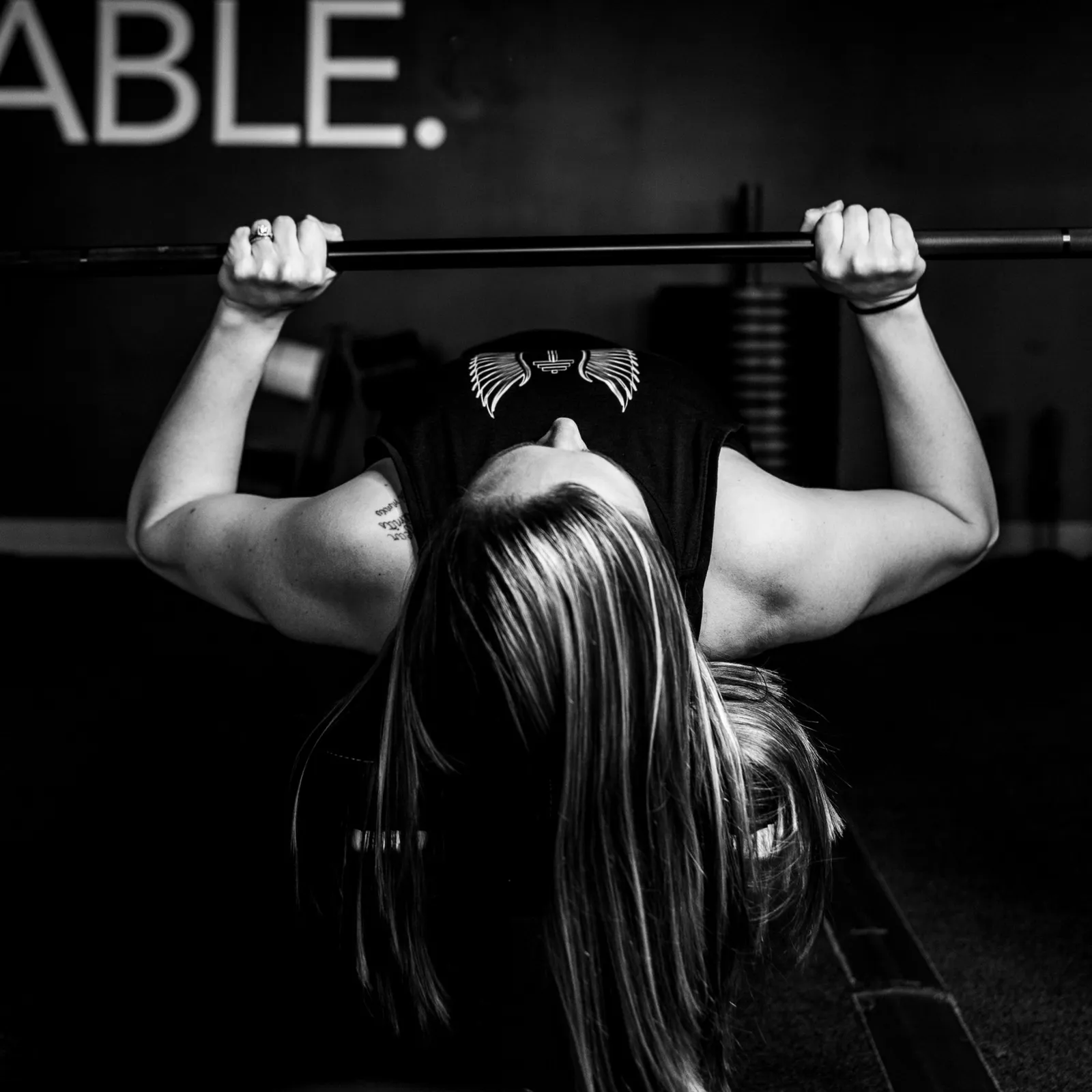 A member setting up under a loaded barbell in the rack